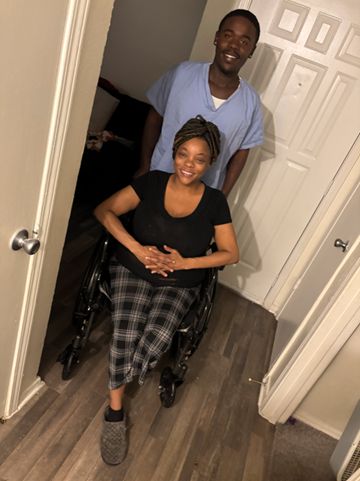 Caregiver providing mobility assistance and wheelchair support